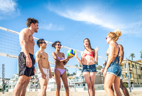 Friends play beach volley © oneinchpunch