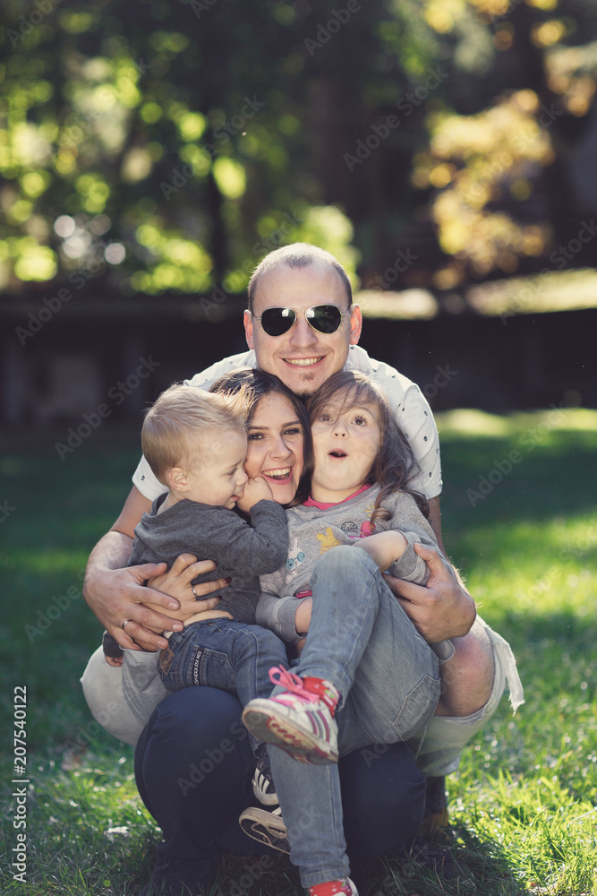 Happy male and female playing with children outside