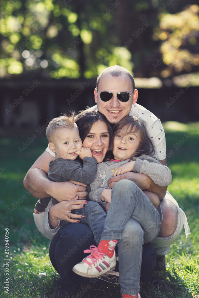 Happy male and female playing with children outside Happy male and female playing with children outside