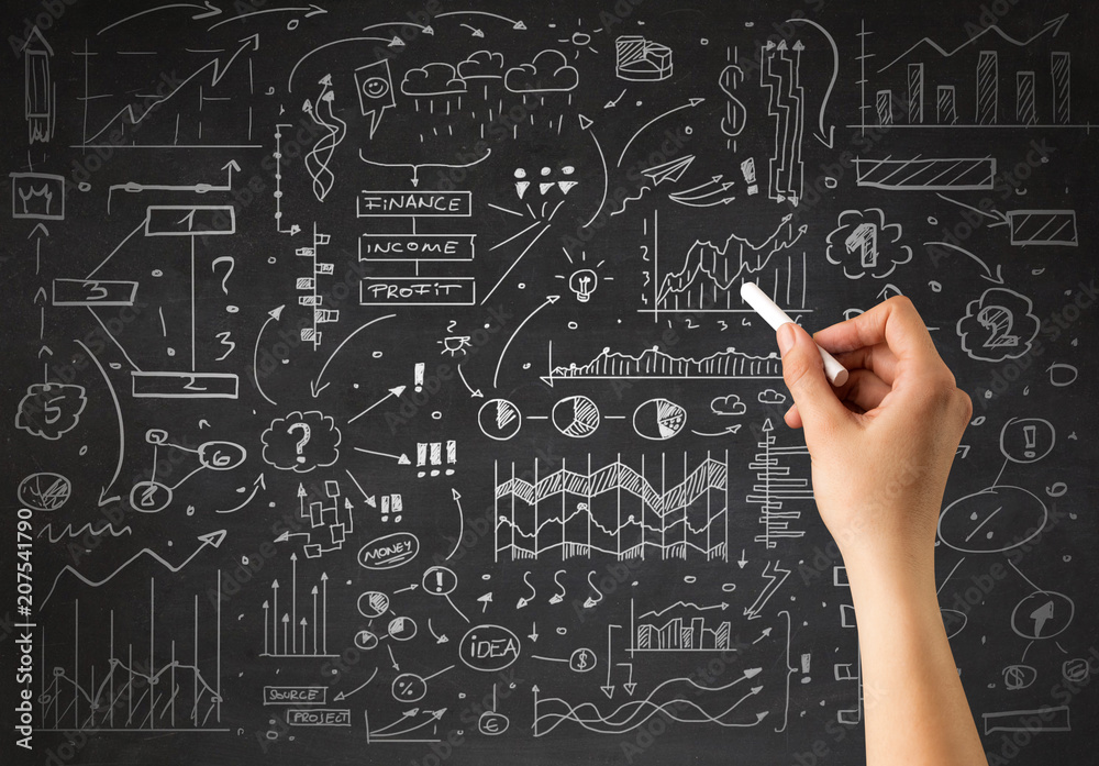 Female hand holding white chalk in front of a blackboard with a business plan drawn on it 
