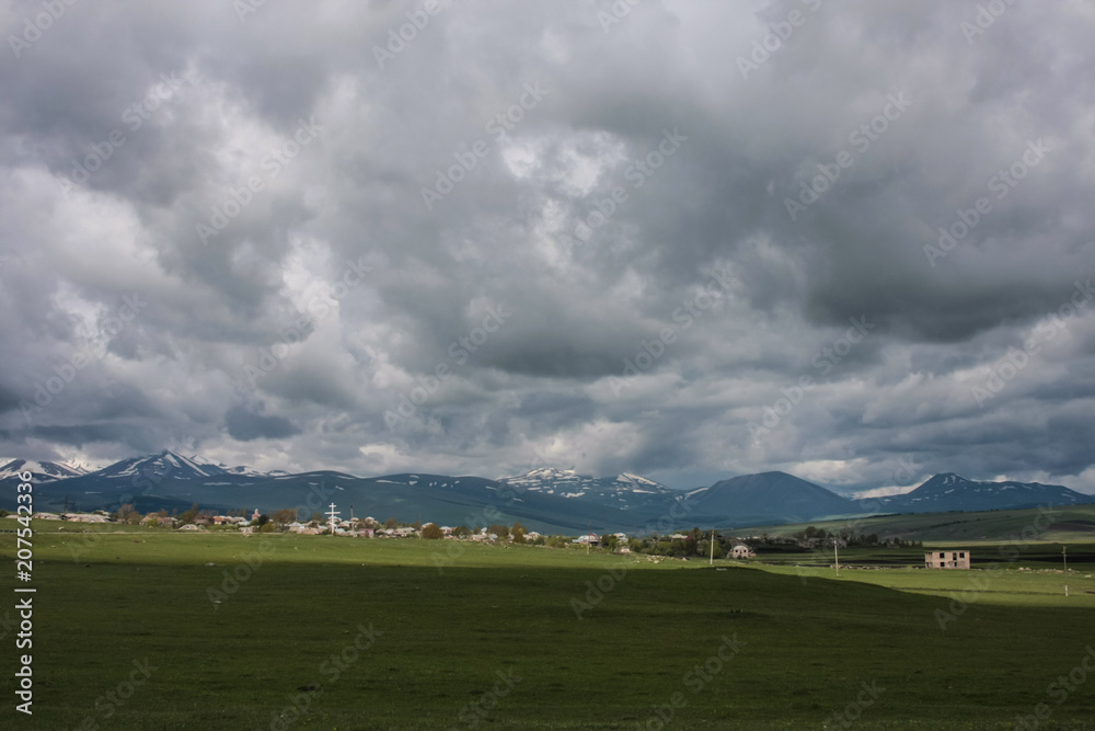 village, mountains and grey clouds
