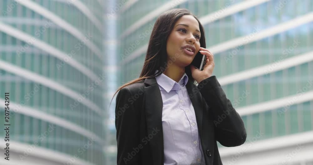A beautiful business woman, she is happy and smiling while sending messages, working emails or calling using the phone, outside the office. A beautiful business woman, she is happy and smiling while sending messages, working emails or calling using the phone, outside the office.