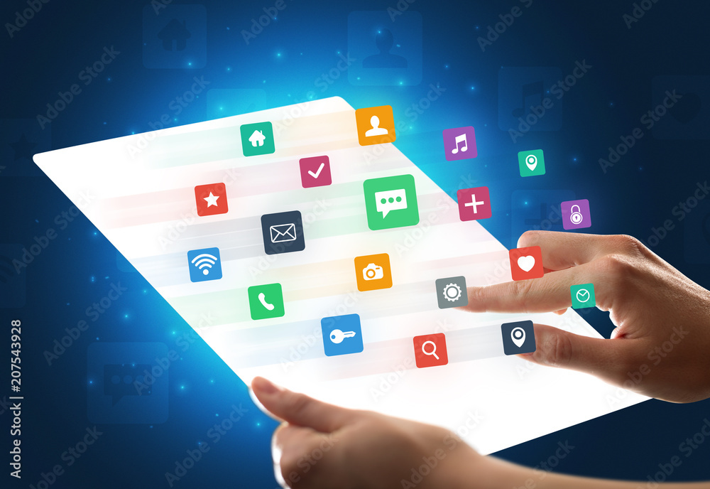 Young female hand holding a tablet with colorful mixed media icons Young female hand holding a tablet with colorful mixed media icons