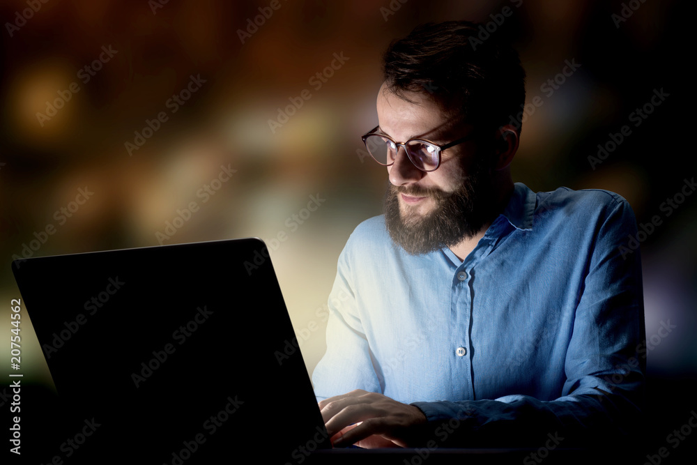 Young handsome businessman working late at night in the office Young handsome businessman working late at night in the office