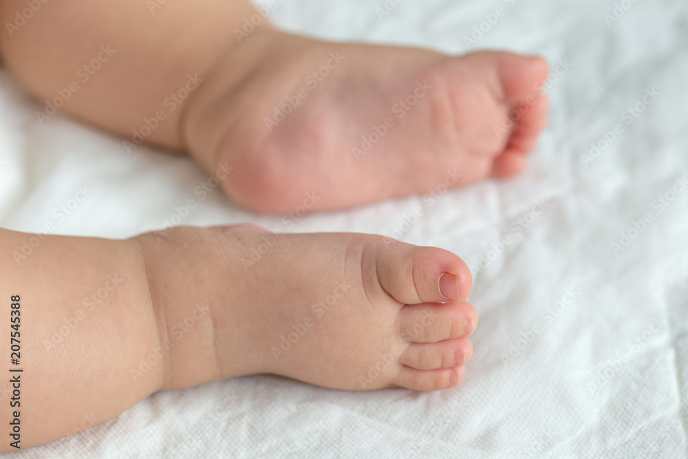 Little baby feet on white soft cloths in the background. Little baby feet on white soft cloths in the background.
