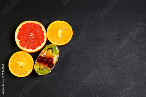 Variety of fruits grapefruit, oranges, kiwi, mint, cake, sweet fruit dessert bunched, together on a shale board, the concept of healthy eating, copy space, top view set