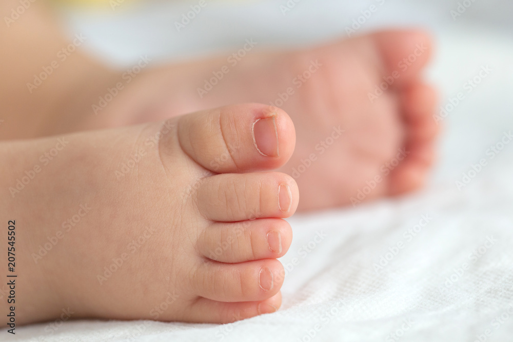 Little baby feet on white soft cloths in the background. Little baby feet on white soft cloths in the background.