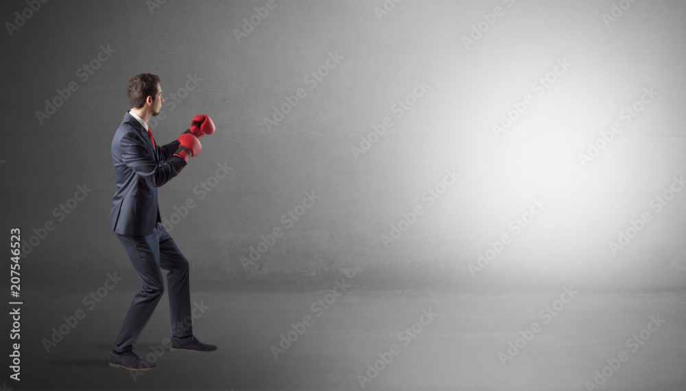 Businessman fighting with boxing gloves in an empty space
Businessman fighting with boxing gloves in an empty space