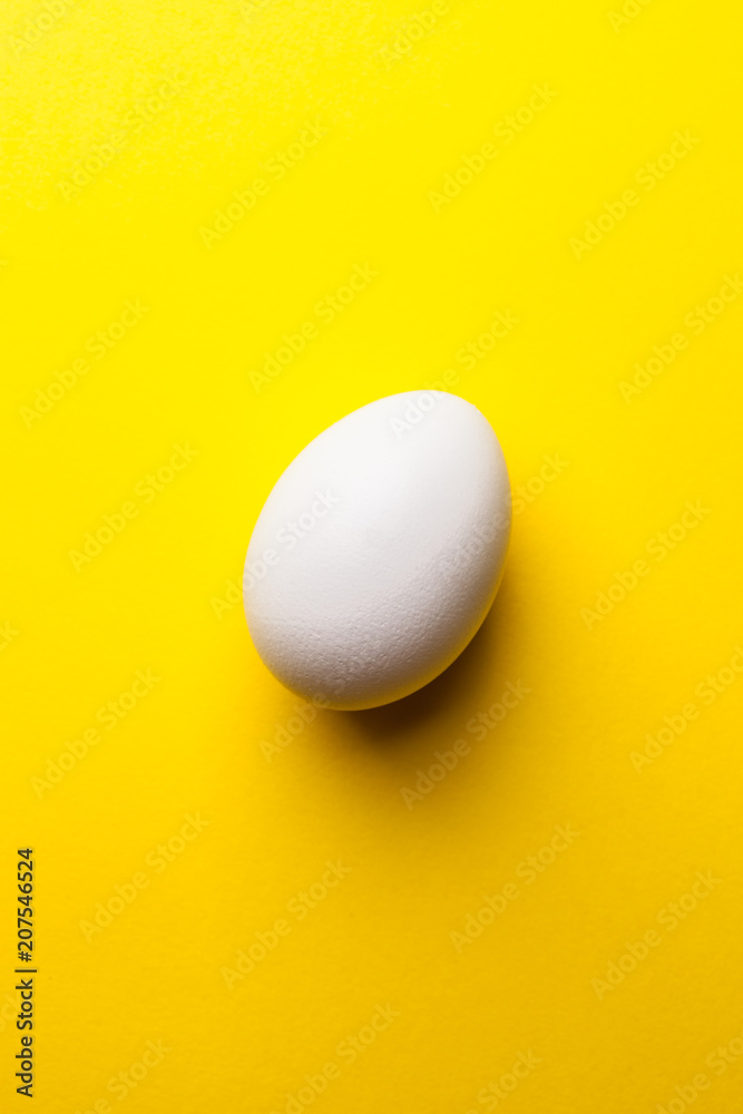 white egg on a yellow background white egg on a yellow background