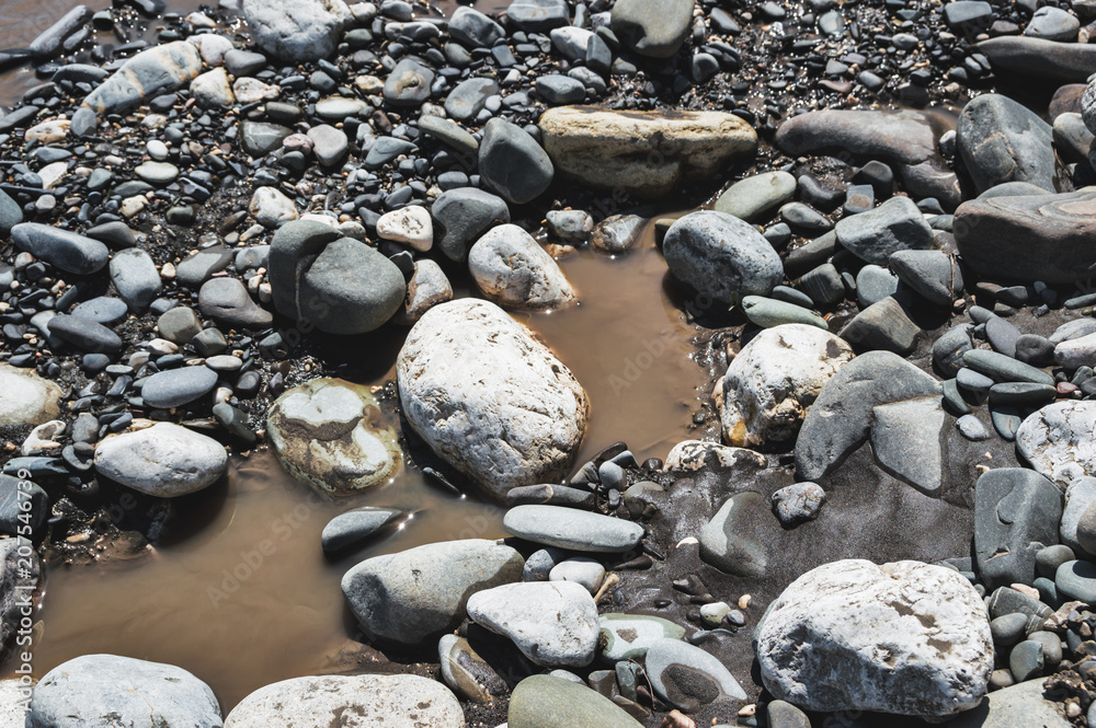 Various stones lying in a dirty pond Various stones lying in a dirty pond