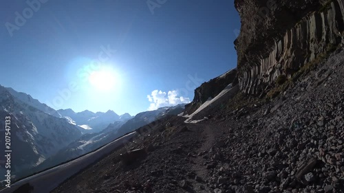 A hiking patway view in the rocky mountains with a blue sky and shining sun background