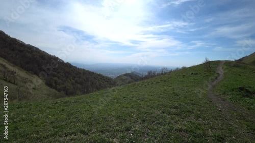 Green hills view with a clouded blue sky background