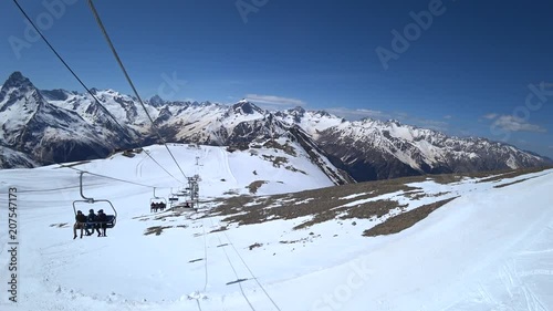 Skiers are climping up to the mountains on the chair lift