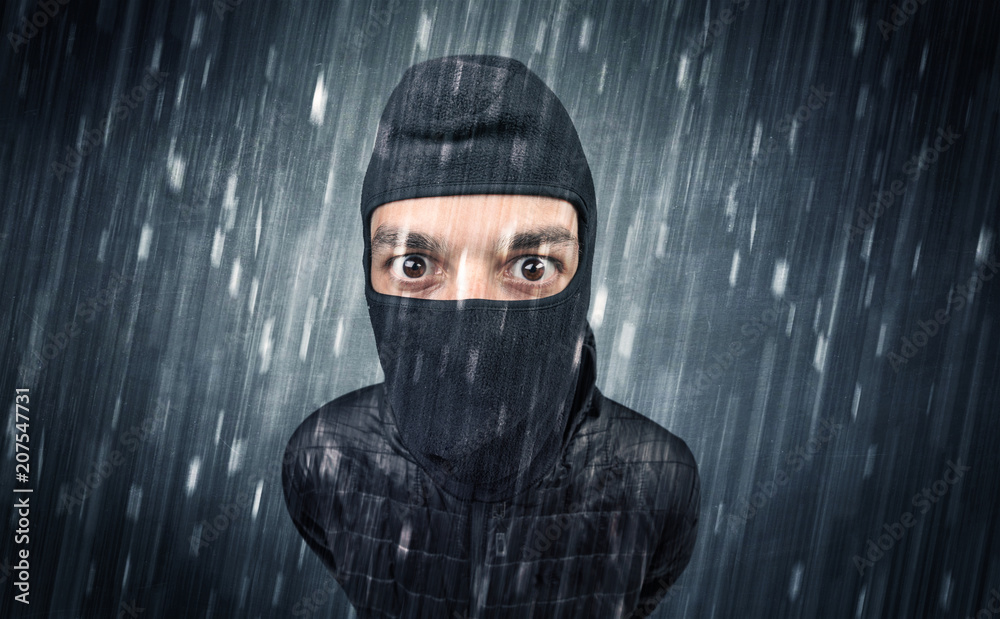 Burglar in action in black clothes with rainy concept. Burglar in action in black clothes with rainy concept.