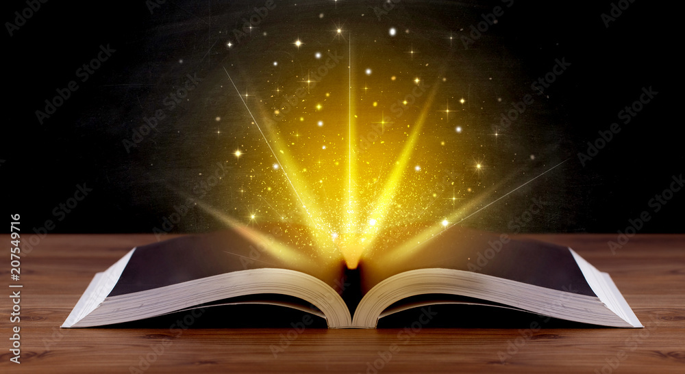 Yellow lights and sparkles coming from an open book Yellow lights and sparkles coming from an open book