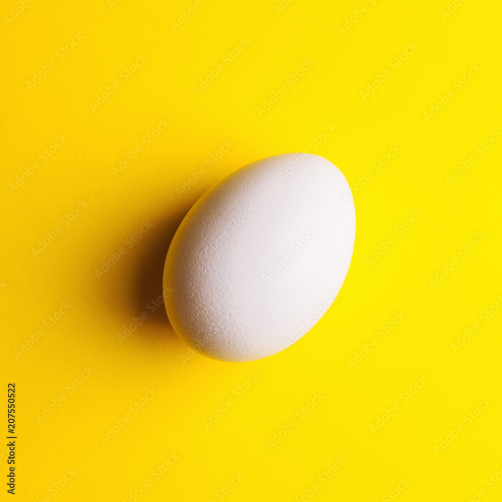 white egg on a yellow background white egg on a yellow background