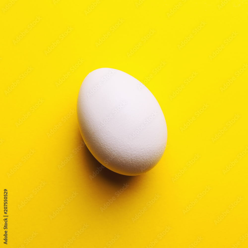 white egg on a yellow background white egg on a yellow background