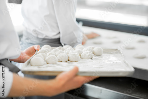 Holding tray with raw dough for buns making at the bakery manufacturnig photo