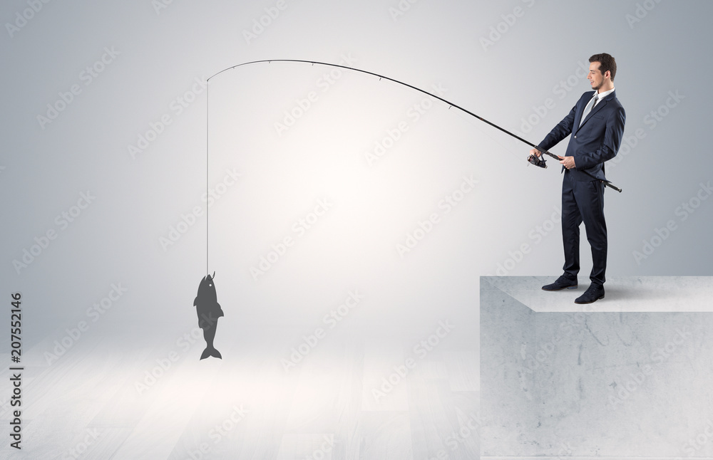 Young businessman fishing golden fish from the top of a building
Young businessman fishing golden fish from the top of a building