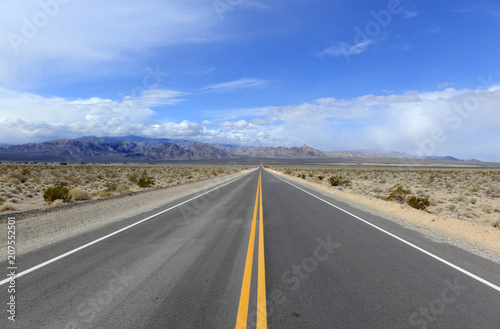 Driving on the open road in the desert with mountain backdrop