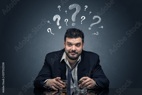 Young drunk disappointed man with question signs concept
