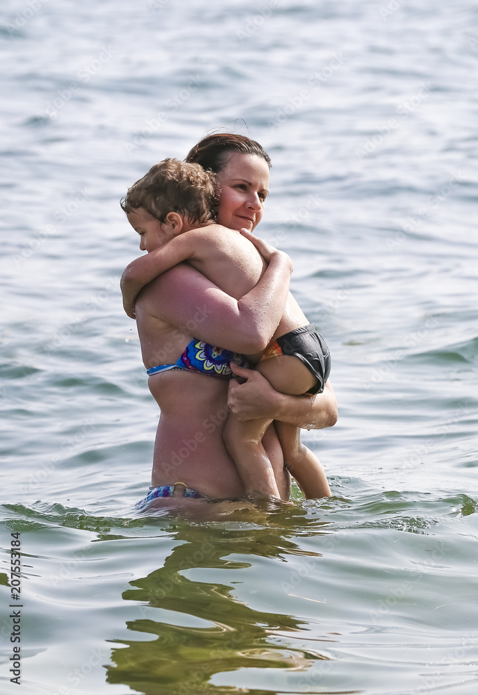Mom with a small son in the sea on the beach. Mom with a small son in the sea on the beach.