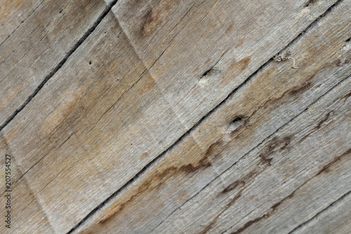 Wood board texture photo. Brown timber with weathered crack lines. Natural background for vintage design.