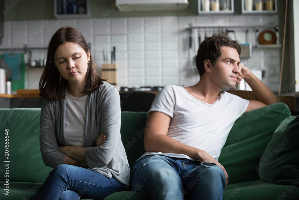 Unhappy millennials ignoring avoiding not talking after fight, frustrated couple in quarrel sitting silent on couch at home having disagreement thinking of misunderstandings in bad relationships Unhappy millennials ignoring avoiding not talking after fight, frustrated couple in quarrel sitting silent on couch at home having disagreement thinking of misunderstandings in bad relationships