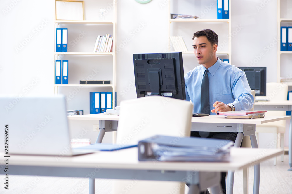 Handsome businessman employee sitting at his desk in office