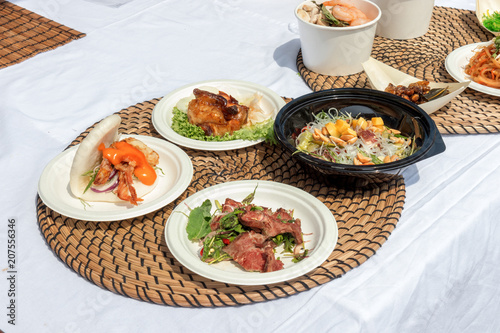 food samples, variations of diverse Asian dishes served on trays during the Asian street farmers market. Soft shell Crab Bao, roasted silkworm, Tom Yum Ramen,