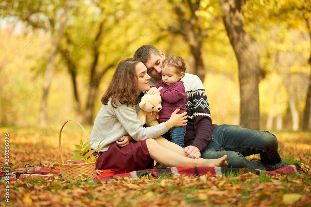 A cheerful family in an autumn park at a picnic. Concept of rest and walk A cheerful family in an autumn park at a picnic. Concept of rest and walk