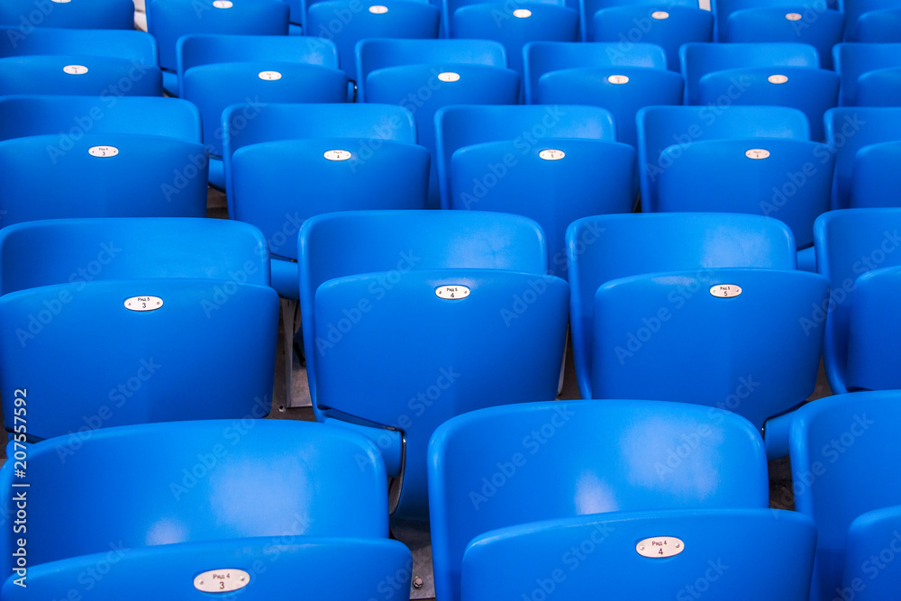 Rows empty bright blue plastic seats in a stadium
