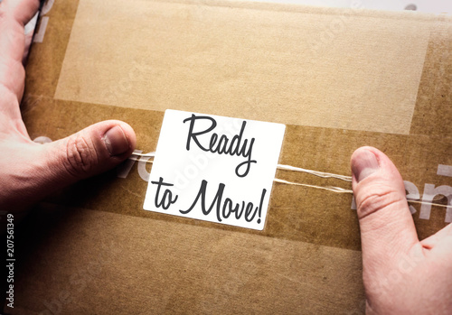 human hands holding cardboars box withe ready to move on small paper photo