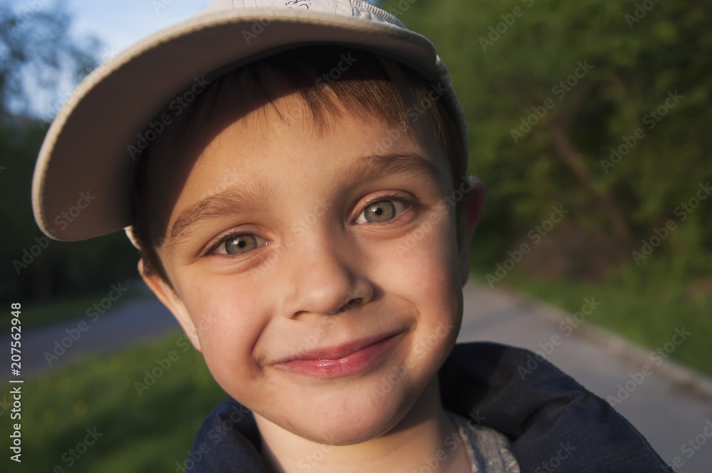 Happy adorable young boy smiling looking at camera close-up. Portrait in nature. Sunset (concept human behavior) Happy adorable young boy smiling looking at camera close-up. Portrait in nature. Sunset (concept human behavior)