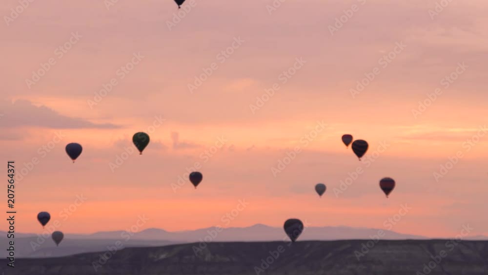 Silhouettes Lots of hot air balloons flying over valleys in Goreme, Turkey. Pink Dawn over the Incredible Place in Turkish Mountains. Silhouettes Lots of hot air balloons flying over valleys in Goreme, Turkey. Pink Dawn over the Incredible Place in Turkish Mountains.