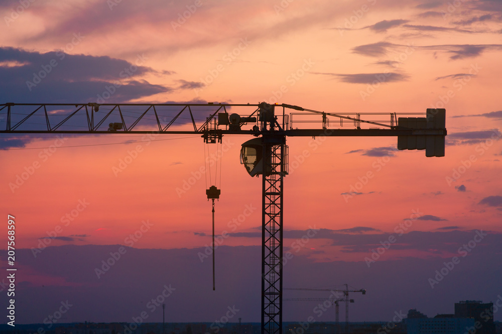 Construction crane against the sky, sunset, cityscape