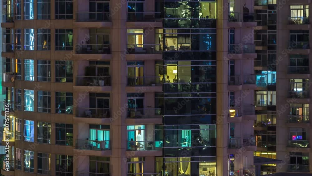 Windows of the multi-storey building of glass and steel lighting inside and moving people within timelapse Windows of the multi-storey building of glass and steel lighting inside and moving people within timelapse