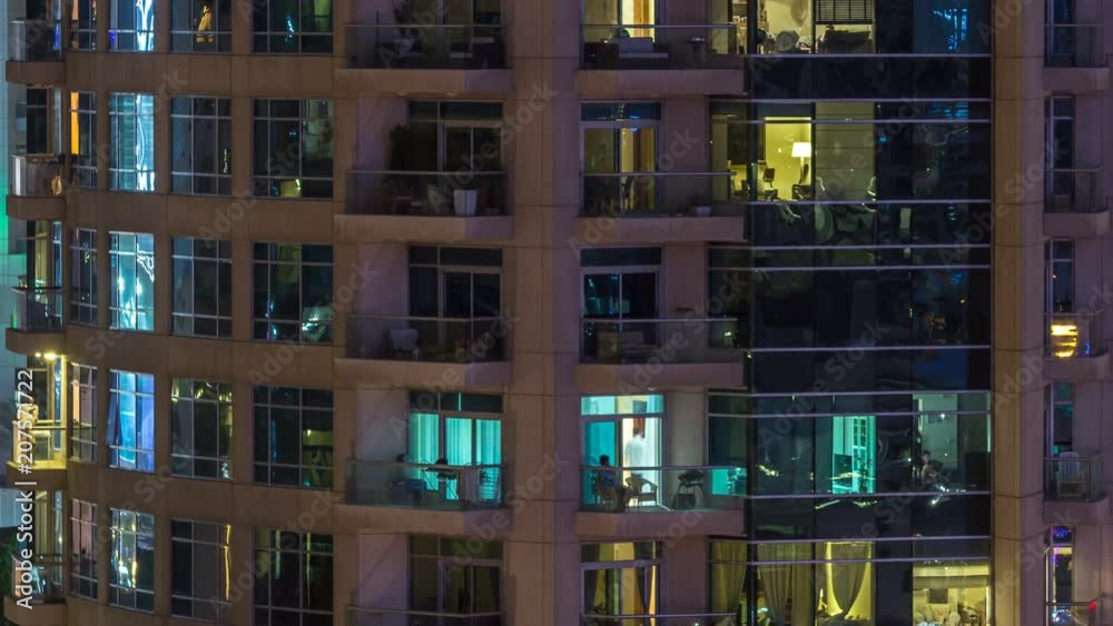 Windows of the multi-storey building of glass and steel lighting inside and moving people within timelapse Windows of the multi-storey building of glass and steel lighting inside and moving people within timelapse
