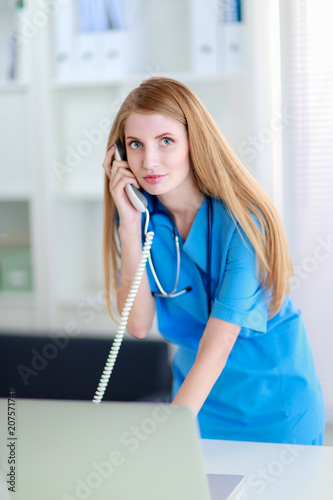 Female doctor talking on phone in diagnostic center photo