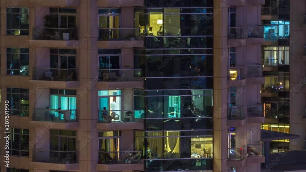 Windows of the multi-storey building of glass and steel lighting inside and moving people within timelapse Windows of the multi-storey building of glass and steel lighting inside and moving people within timelapse