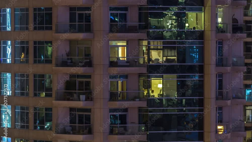 Windows of the multi-storey building of glass and steel lighting inside and moving people within timelapse Windows of the multi-storey building of glass and steel lighting inside and moving people within timelapse
