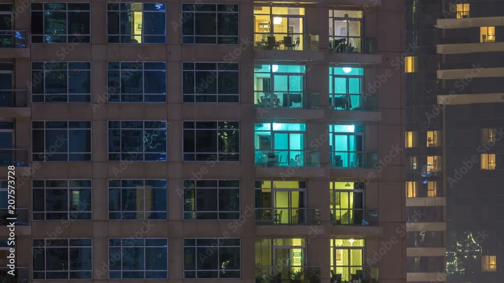 Windows of the multi-storey building of glass and steel lighting inside and moving people within timelapse Windows of the multi-storey building of glass and steel lighting inside and moving people within timelapse