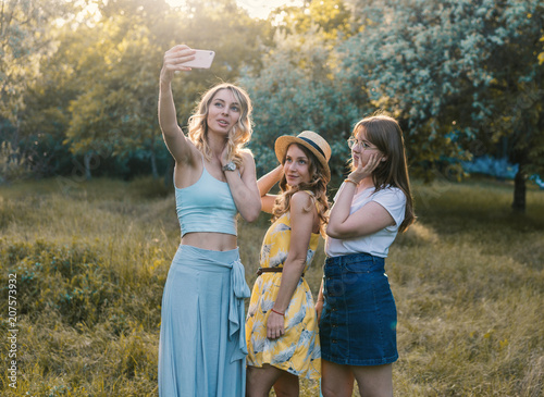 Group of girls friends making picnic outdoor. They make selfie photo from smartphone. bachelorette  party