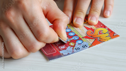 Hands scratching the lottery.