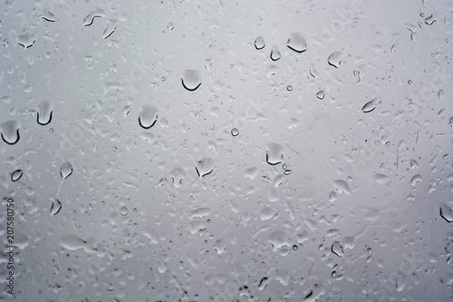 Water rain drop on wet weeping grey surface of window glass. Texture. Background
