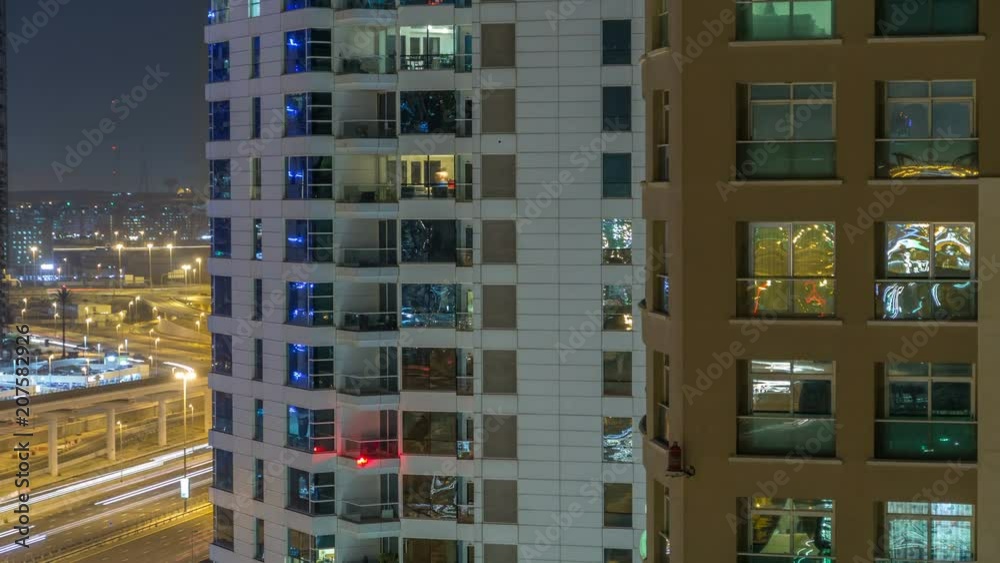 Windows of the multi-storey building of glass and steel lighting inside and moving people within timelapse Windows of the multi-storey building of glass and steel lighting inside and moving people within timelapse