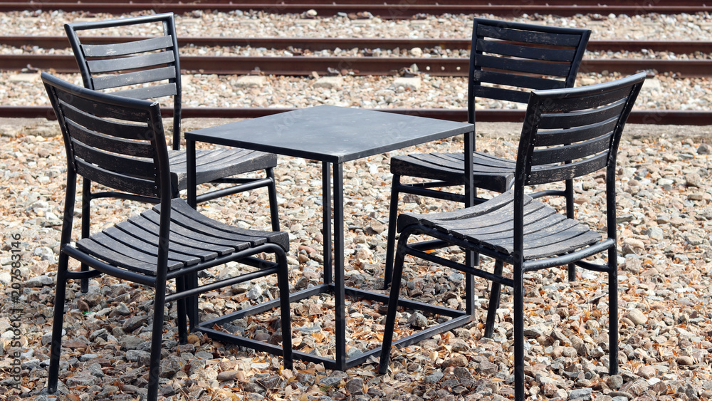 An empty table and chair by the railroad. An empty table and chair by the railroad.