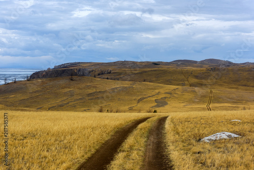 Track winding back roads in the mountains. Dirt road on Olkhon island in lake Baikal. photo