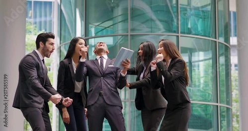 A group of business people from different ethnic backgrounds rejoices and celebrates their success in the financial and economic fields. Concept of: team work, internationality and success.