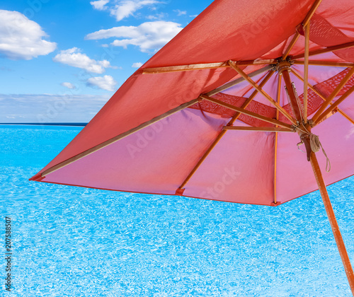 parasol sur piscine à débordement avec vue sur l'horizon 